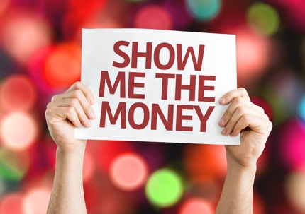 hands holding up sign that says SHOW ME THE MONEY on a blurred multicolored light background.