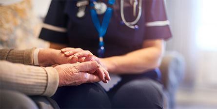 nurse holding elder person's hands