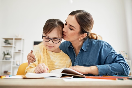 mother teaching daughter how to read a book