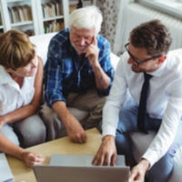 attorney and elder couple looking at laptop